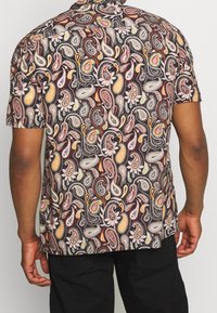 Kortärmad skjorta i mörkt tyg med ett färgstarkt paisleymönster med intrikata detaljer i orange, vitt och röda nyanser.