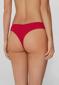 Czerwone figi bikini o gładkiej, elastycznej fakturze. Charakteryzują się minimalistycznym krojem i bezszwowymi krawędziami, oferując niskowzrostowy design.