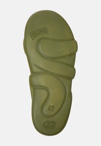Green rubber flip-flop sole with a wave-like design. Features the brand "Camper" and size "42" embossed. Smooth texture, rounded edges.