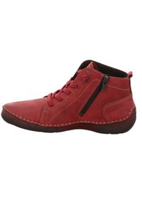 Bottine chevillère en cuir rouge avec un bout arrondi, fermeture à lacets et zip sur le côté. Présente des coutures contrastantes et une surface texturée.
