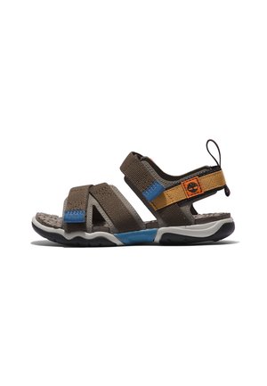 Sandale marron et bleue à bout ouvert avec des brides réglables et une semelle texturée, avec une lanière couleur sable et un petit patch logo sur le côté.