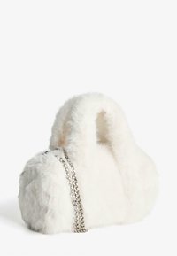 Bijela torba od umjetnog krzna okruglog oblika, s srebrnim lančićem i mekom teksturom. Torba ima dvije kratke ručke za nošenje.
