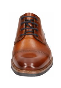 Zapato de cuero marrón con un acabado suave, punta redonda y cordones negros. Presenta una suela clara en contraste y un detalle de costura a lo largo del borde.