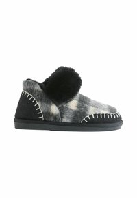 Chausson duveteux gris et noir à forme arrondie, orné d'un pompon, avec des surpiqûres blanches contrastantes et une tige en tissu texturé.
