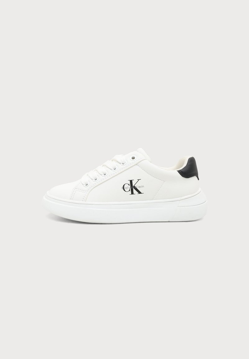 Λευκό χαμηλό sneaker με μαύρο ταμπελάκι φτέρνας, λευκά κορδόνια και λογότυπο Calvin Klein στο πλάι, εμφανίζεται από την εξωτερική πλευρά.