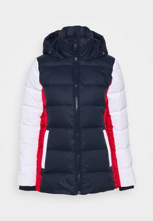 Steppjacke mit einem dunkelblauen Oberteil, roten und weißen Seitenteilen, hohem Kragen, Frontreißverschluss und gestepptem Muster. Geeignet für kalte Wetterbedingungen.