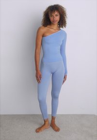 Svetlo modra bodysuit brez ramena z dolgim rokavom, rebrasta tekstura, prilegajoča zasnova, v kompletu s prilegajočimi legginsami.
