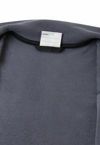 Grauer Stoff mit glatter Textur. Verfügt über einen schwarzen Rand und ein Etikett mit der Aufschrift "Ich war hier:" und Linien zur Anpassung.