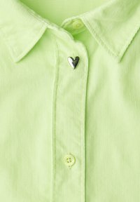 Jasnozielona koszula z kołnierzykiem o prążkowanej fakturze, z błyszczącym srebrnym guzikiem w kształcie serca oraz standardowym zapięciem na guziki.