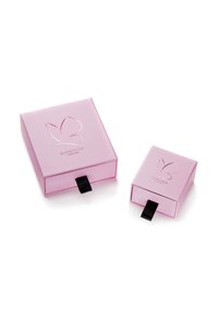 Duos rožinių kvadratinių dovanu dėžučių su juodais vilkimo užtrauktukais, ant kurių yra drugelio logotipas ir tekstas „GLANZSTÜCKE MÜNCHEN“.