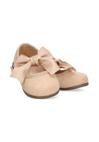 Par de zapatos para toddler de color rosa pálido con grandes lazos de satén y textura suave de ante, suelas planas marrones y cierres de correa de gancho y bucle.