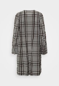 Cappotto lungo a quadri marroni e bianchi con una vestibilità rilassata, caratterizzato da maniche lunghe, scollo rotondo e tessuto testurizzato. Strisce verticali nel design.