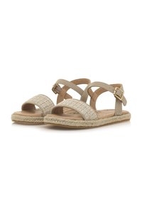 Sandal de color beige con parte superior de tejido trenzado, correas cruzadas, hebilla en el tobillo y plantilla texturizada. Media suela de yute trenzado y suela de goma.