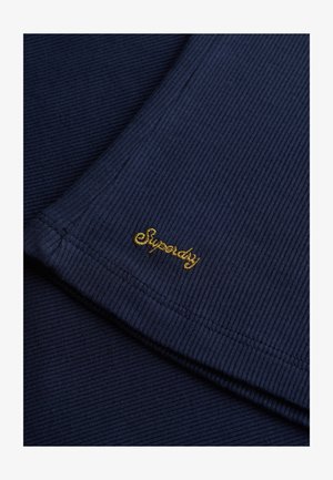 Granatowa, prążkowana tkanina z złotym haftem "Superdry". Charakteryzuje się gładką fakturą i starannie wykończonymi krawędziami.