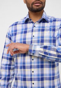Blau- und gelb kariertes Hemd mit langen Ärmeln, Button-down-Kragen, Brusttasche und blauen Knöpfen, aus einem strukturierten Baumwollstoff.