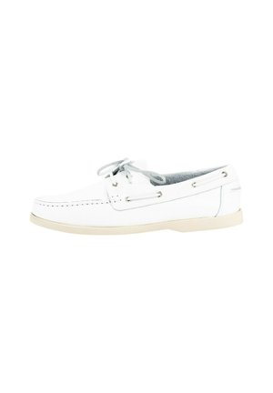 Zapato de barco blanco hecho de cuero suave, con un perfil bajo, cordones grises y ojales de metal. Suela de goma de color claro con detalles de costura.