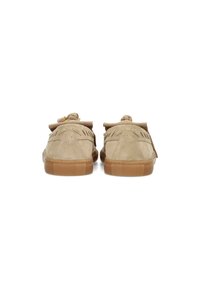 Scarpe in suede beige con suola in gomma piatta, caratterizzate da un design frangiato e dettagli di perline decorative sui tappi del tallone, viste da dietro.