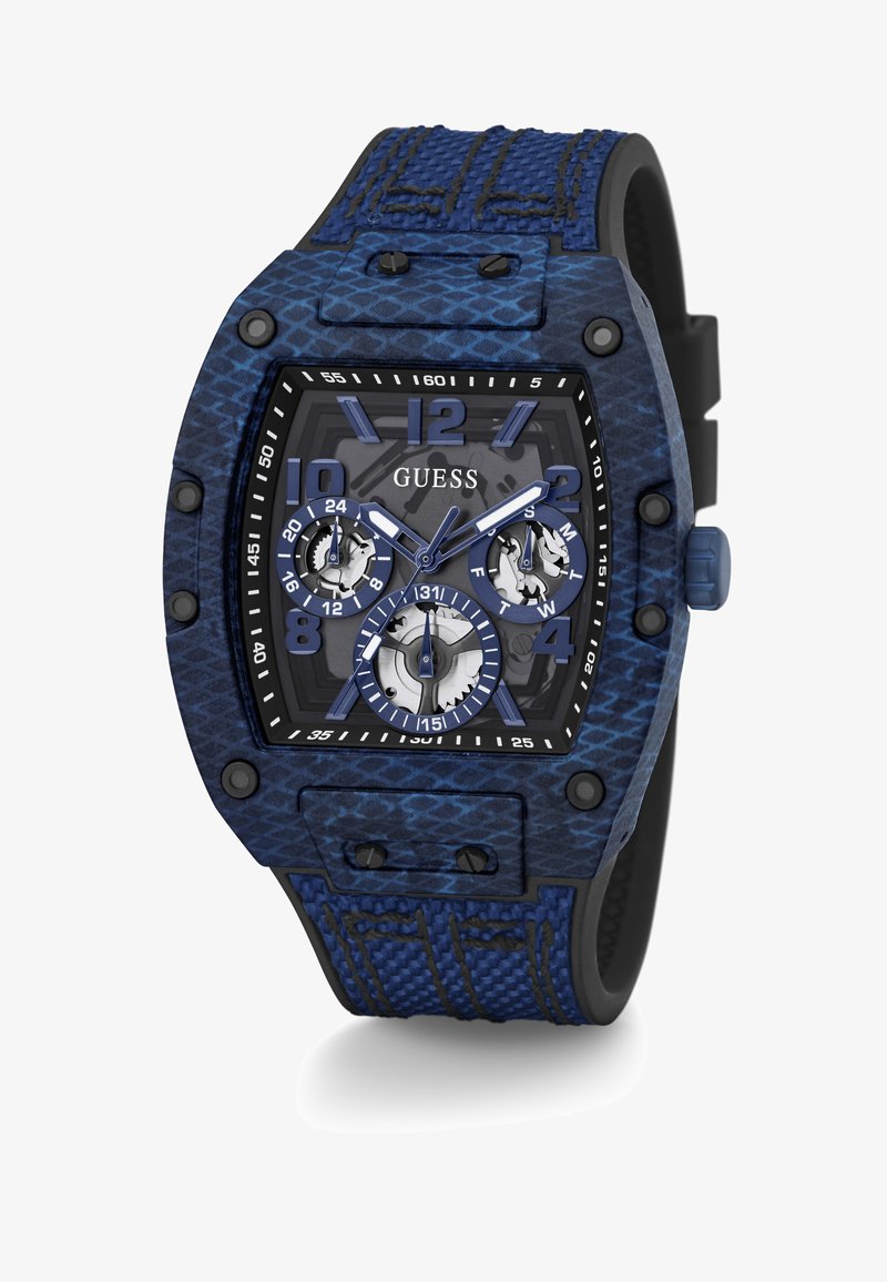 El reloj cronógrafo Guess presenta una correa de silicona texturizada en azul, una caja texturizada en negro y tres subesferas sobre un fondo de esfera gris.