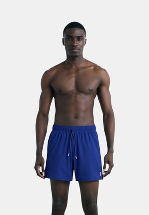 Costumi da bagno blu navy realizzati in tessuto ad asciugatura rapida, con cintura elastica, cordoncino e tasche laterali. Design semplice e funzionale.