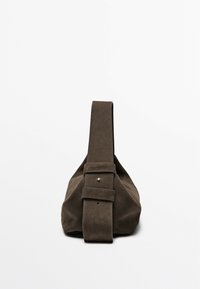 Brown suede bag with a wide, flat strap and a buckle accent. Features a soft, structured shape with visible stitching details.
