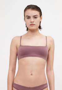 Bledomodrý bavlnený bikiny top s tenk�ými nastaviteľnými ramienkami a jednoduchým, bezšvovým dizajnom. Ľahký s hladkou textúrou a minimalistickým štýlom.