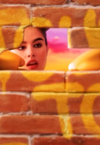 Una donna con rossetto rosso sbircia attraverso un foro rettangolare in un muro di mattoni con graffiti gialli, contro uno sfondo di cielo colorato rosa e arancione.
