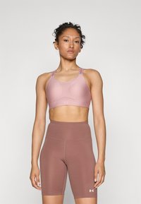 Sport-bh og høyt midjebåndshorts i lys mauve; glatt stoff med subtil tekstur; støttende design; logo på midjebåndet og stropper.