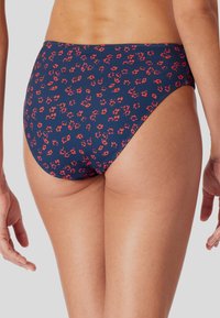 Marine bikini onderkant met een klein rood bloemenpatroon. Heeft een hoog uitgesneden beenontwerp en een gladde textuur, vervaardigd uit rekbaar materiaal.