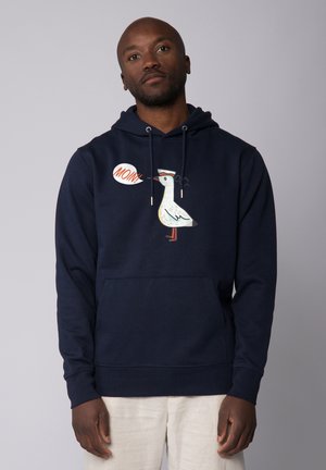 Marineblauw sweatshirt met een voorkant zak, met een witte meeuwafbeelding en de tekst "MOIN!" in een spraakballon. Gemaakt van zachte stof.