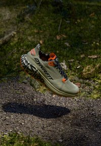 Ελαφριά αθλητικά παπούτσια τρεξίματος σε ελαιόλαδο πράσινο με πορτοκαλί λεπτομέρειες. Διαθέτουν αναπνεύσιμο άνω μέρος, υφασμάτινη σόλα και μοτίβο στα πλάγια για καλύτερη πρόσφυση.