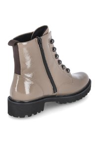 Stivale alla caviglia in pelle sintetica beige con suola in gomma nera, zip laterale e bottoni neri decorativi sulla parte anteriore. Design del tacco rinforzato.