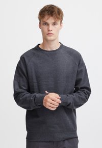 Dunkelgrau sweatshirt mit Rundhalsausschnitt, Raglanärmeln, gerippten Bündchen und Saum. Hergestellt aus weichem Stoff mit glatter Textur.
