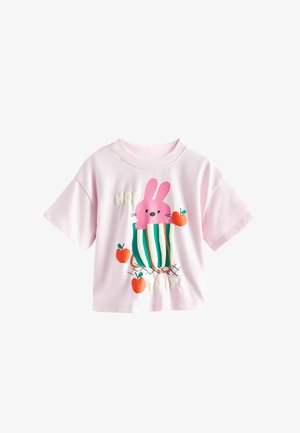 Light pink short-sleeve shirt with a design of a pink bunny in a green-striped basket surrounded by three red apples.