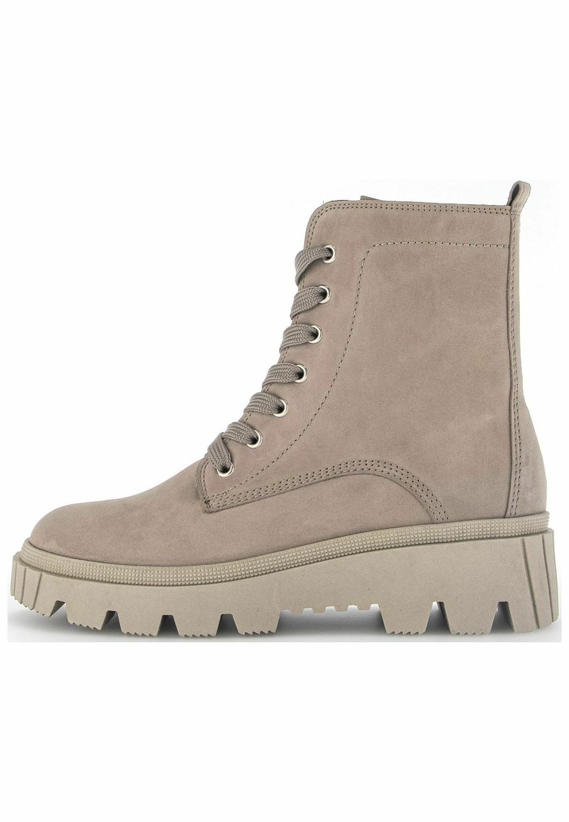 Beige suede ankle boot with round toe, lace-up front, silver eyelets, and chunky rubber sole. Side stitching details and reinforced heel.