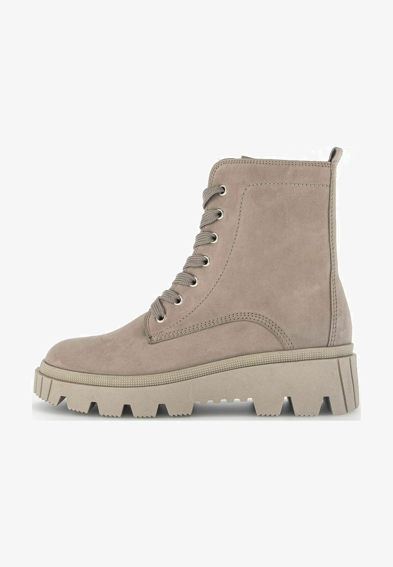Beige suede ankle boot with round toe, lace-up front, silver eyelets, and chunky rubber sole. Side stitching details and reinforced heel.