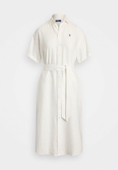 Robe chemise en lin blanc avec des manches courtes, boutonnage à l'avant et une ceinture assortie. Présente un petit logo brodé sur la poitrine.