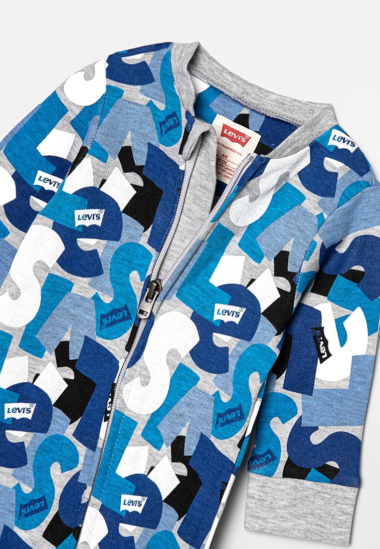 Blå sweatshirt med grå detaljer, featuring dragkedja, livliga blandade logomönster och mjukt texturerat tyg. Datummärkning synlig inuti.