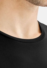 Svart kortärmad T-shirt med en slät textur och rundad halsringning, med en närbild av krageområdet mot hud.