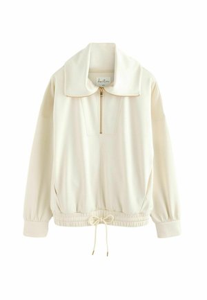 Pull-over crème à manches longues avec fermeture éclair sur le devant, col large, poignets élastiques et taille avec cordon.