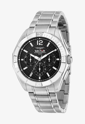 Montre chronographe en métal argenté avec un cadran en fibre de carbone noir, index blancs, poussoirs en argent et bracelet à maillons. Résistante à l'eau jusqu'à 100 m.