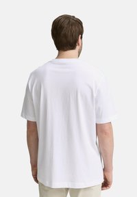 Witte katoenen t-shirt met een ronde hals en korte mouwen, met een eenvoudige en gladde textuur, gezien vanaf de achterkant.