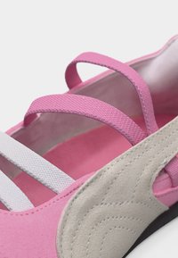 Ροζ και μπεζ παπούτσι με πολλαπλούς λουράκια με υφή, που αναδεικνύουν τα ραφτά πλαϊνά πάνελ και το μαλακό εσωτερικό ύφασμα.