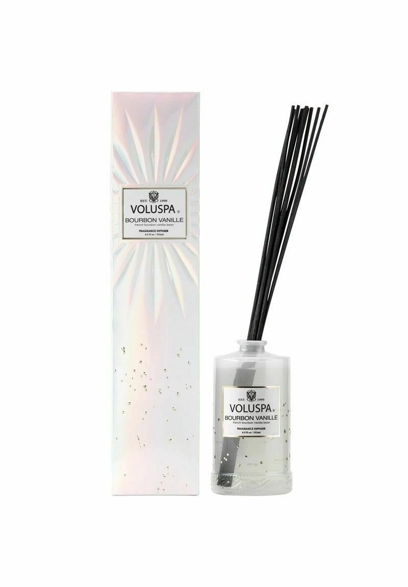 Voluspa Bourbon Vanille diffuser med en klar glasflaske, sorte rør og en iriserende æske med guldprikker og en sort etiket.