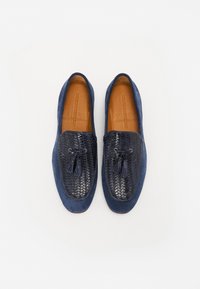 Loaferi din suede albastru marin, cu un panou din piele neagră împletită și ciucuri, vârf rotund și o branț din piele maro netedă.