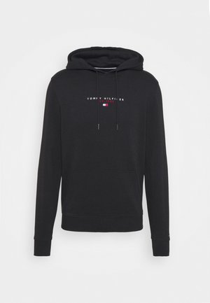Schwarzer Hoodie mit Fronttasche, Kordelzugkapuze und "Tommy Hilfiger Est. 1985" Logo mit weißem, rotem und blauem Flaggenmotiv auf der Brust.