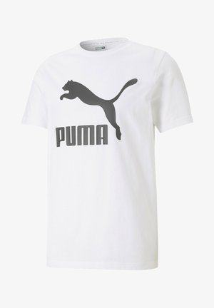 Fehér pamut póló, nagy fekete Puma logóval és egy ugró macska sziluettjével. Kerek nyakkivágással, rövid ujjú és egyenes aljjal.