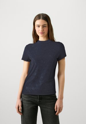 Camiseta de manga corta azul marino con un cuello alto, que presenta un patrón de diamantes acentuado por un sutil brillo y una textura de tela suave.