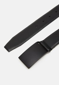 Schwarzer Leder-Gürtel mit glatter Oberfläche, rechteckiger Metallschnalle und Verstelllöchern entlang des Riemens zur Größenanpassung.