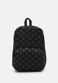 Sac à dos noir avec un motif de logo gris répétitif, fabriqué en tissu durable, comportant deux compartiments zippés et une poignée supérieure.