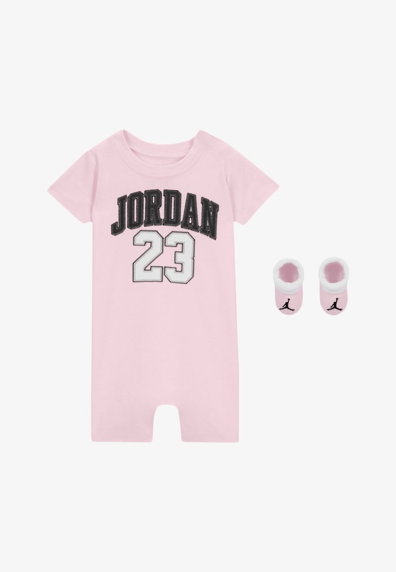 Un monito rosa con "JORDAN" en letras negras y "23" en blanco, acompañado de calcetines rosa a juego con acentos de logo negro.